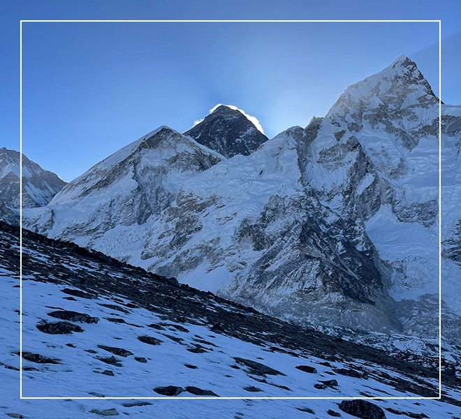 A mountain with snow on it and the sun shining