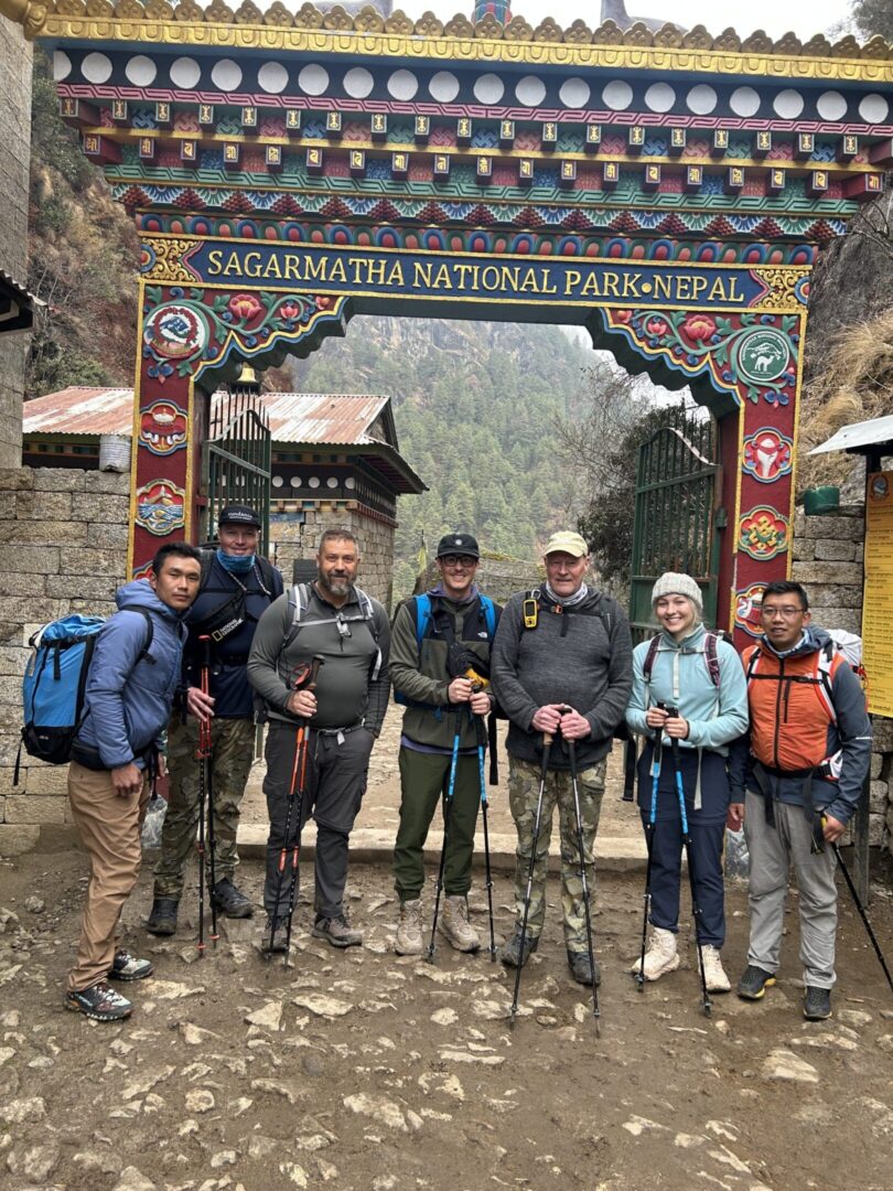 A group of people standing in front of a sign.