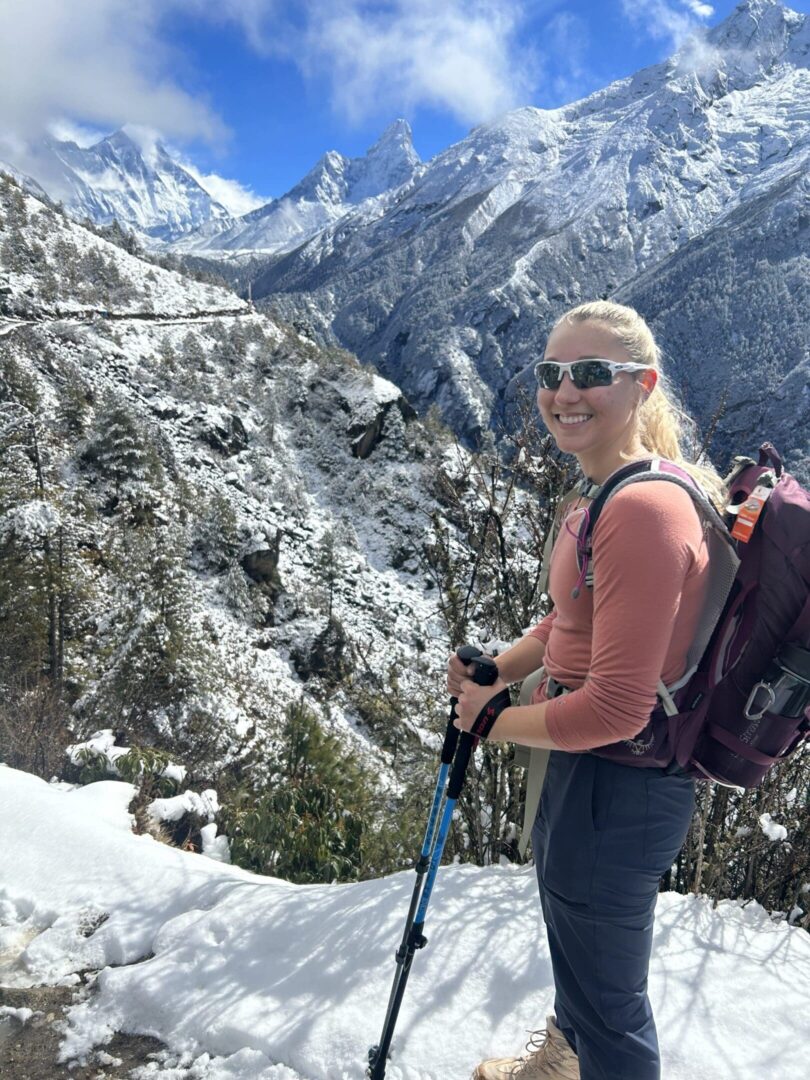 A woman standing on top of a snow covered slope.