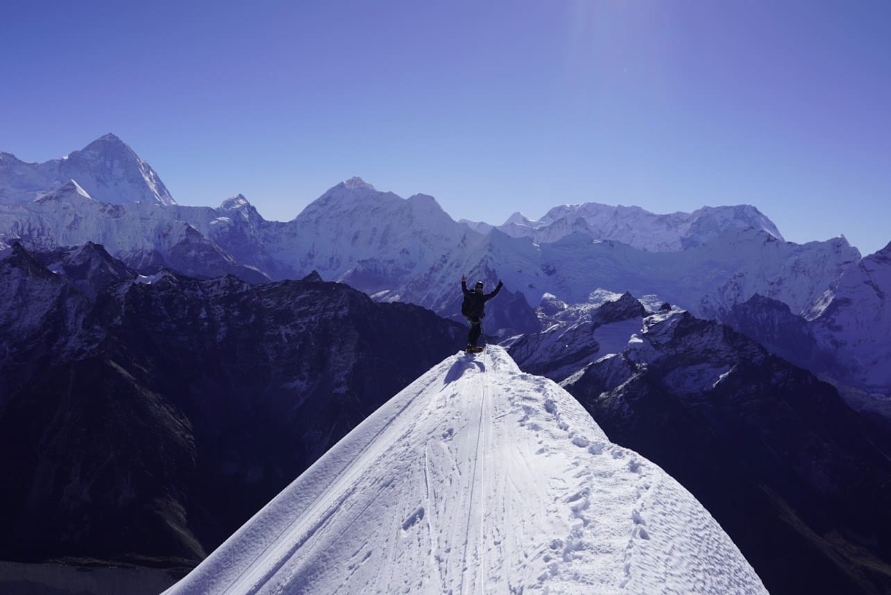 A person on skis standing on top of a mountain.