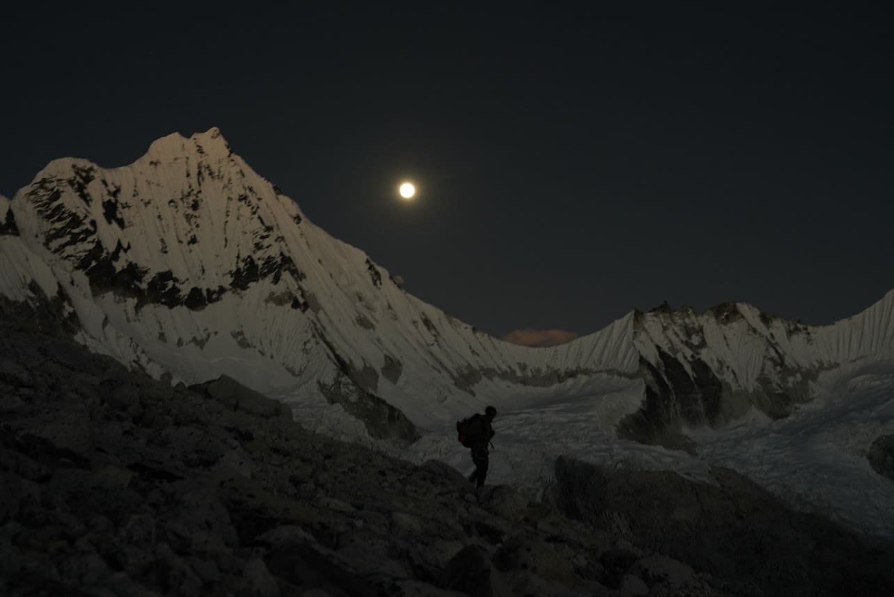 A person standing on top of a snow covered mountain.