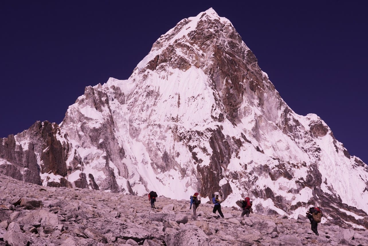 A group of people climbing up the side of a mountain.