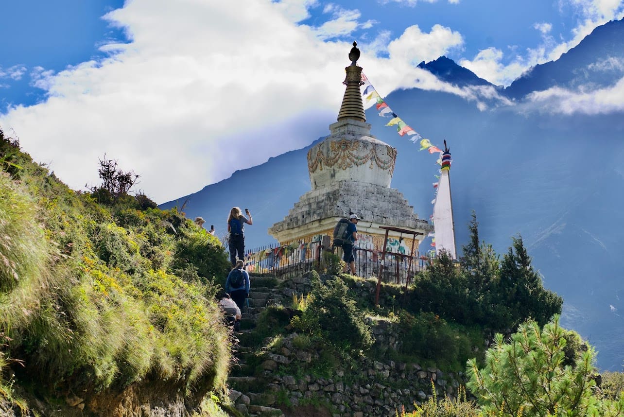 A person standing on top of a hill near a building.