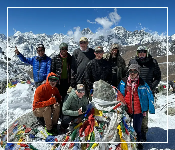 A group of people standing on top of a snow covered slope.